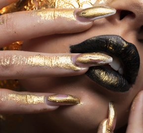 Beauty fashion model girl with golden makeup-body black background-golden body art