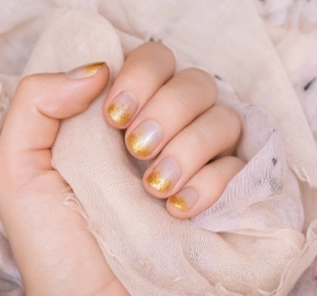Female hand with gold glitter nail design