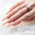 Hand young woman with white pearl manicure